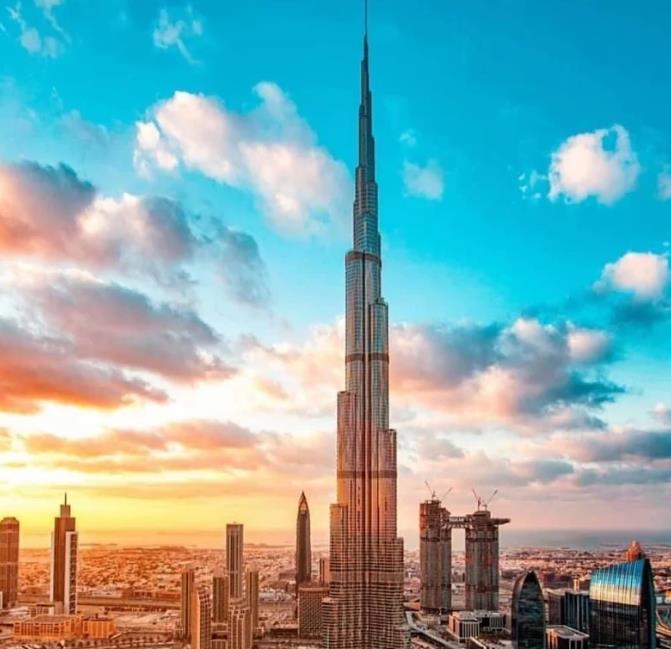 A stunning view of the Burj Khalifa against a colorful sunset sky, surrounded by modern skyscrapers.